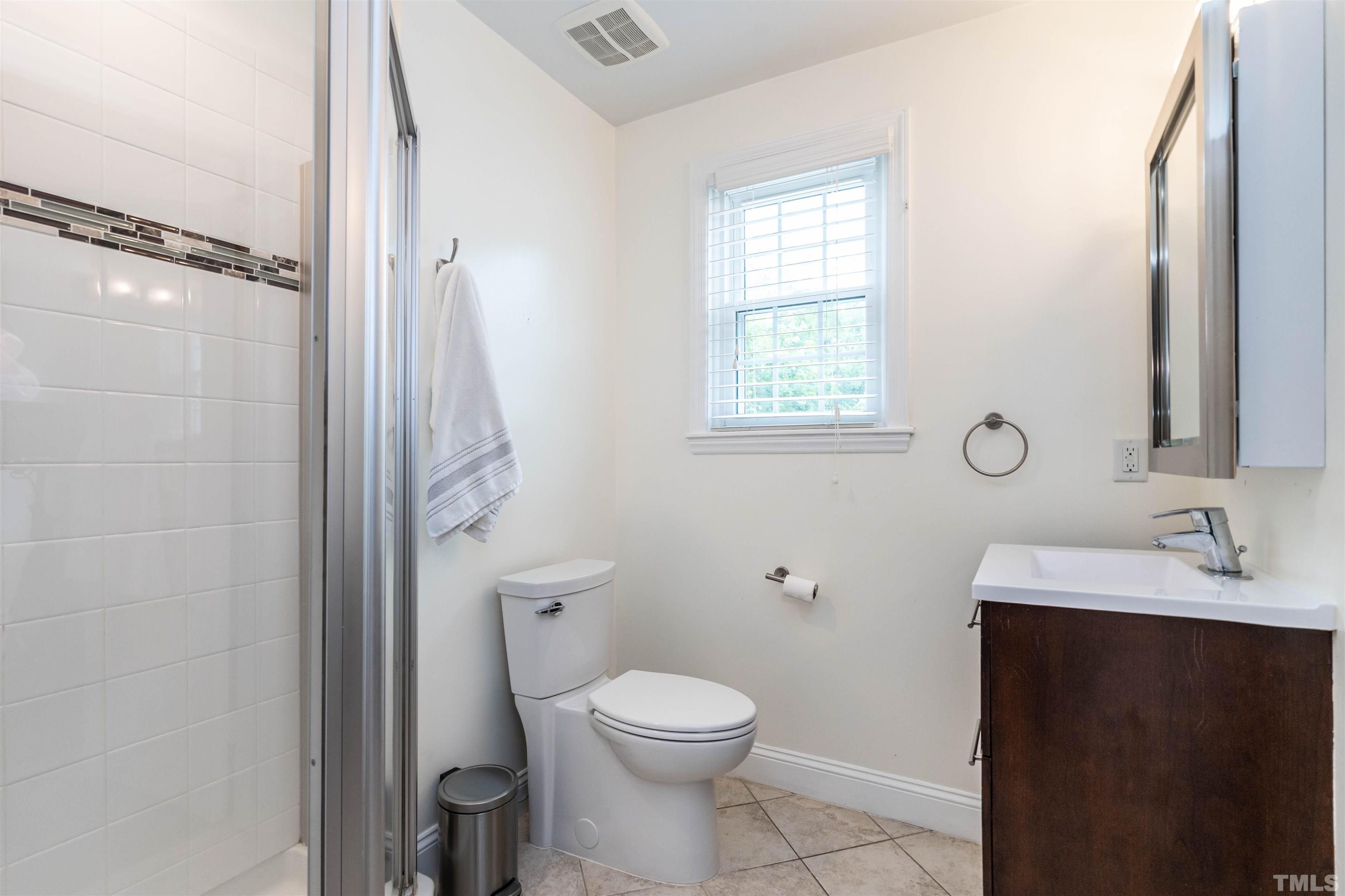 1204 Clifton Street Raleigh, NC 27604 - Photo 15 of 26 a bathroom with a toilet a sink a vanity and mirror