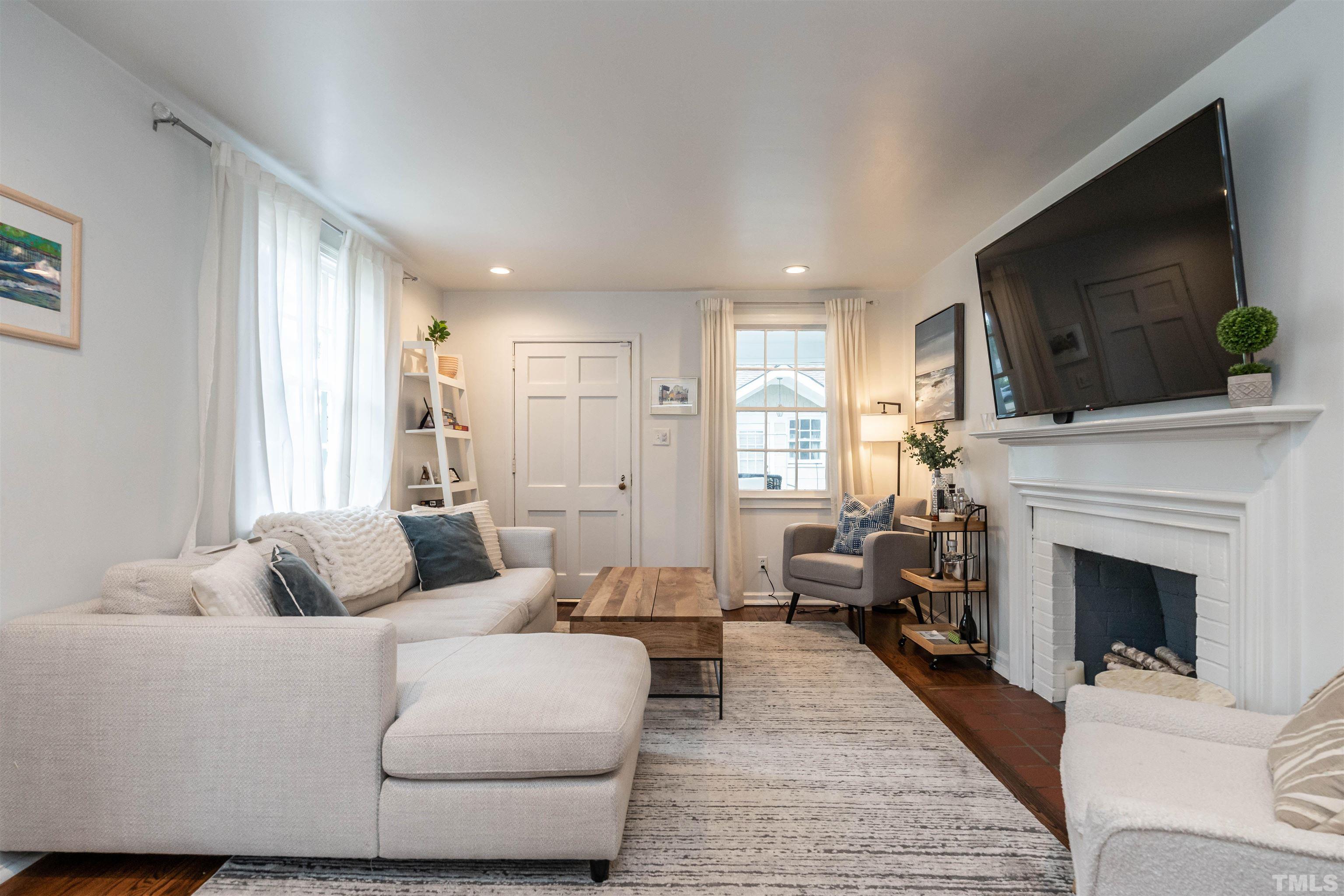 1204 Clifton Street Raleigh, NC 27604 - Photo 4 of 26 a living room with furniture a flat screen tv and a fireplace