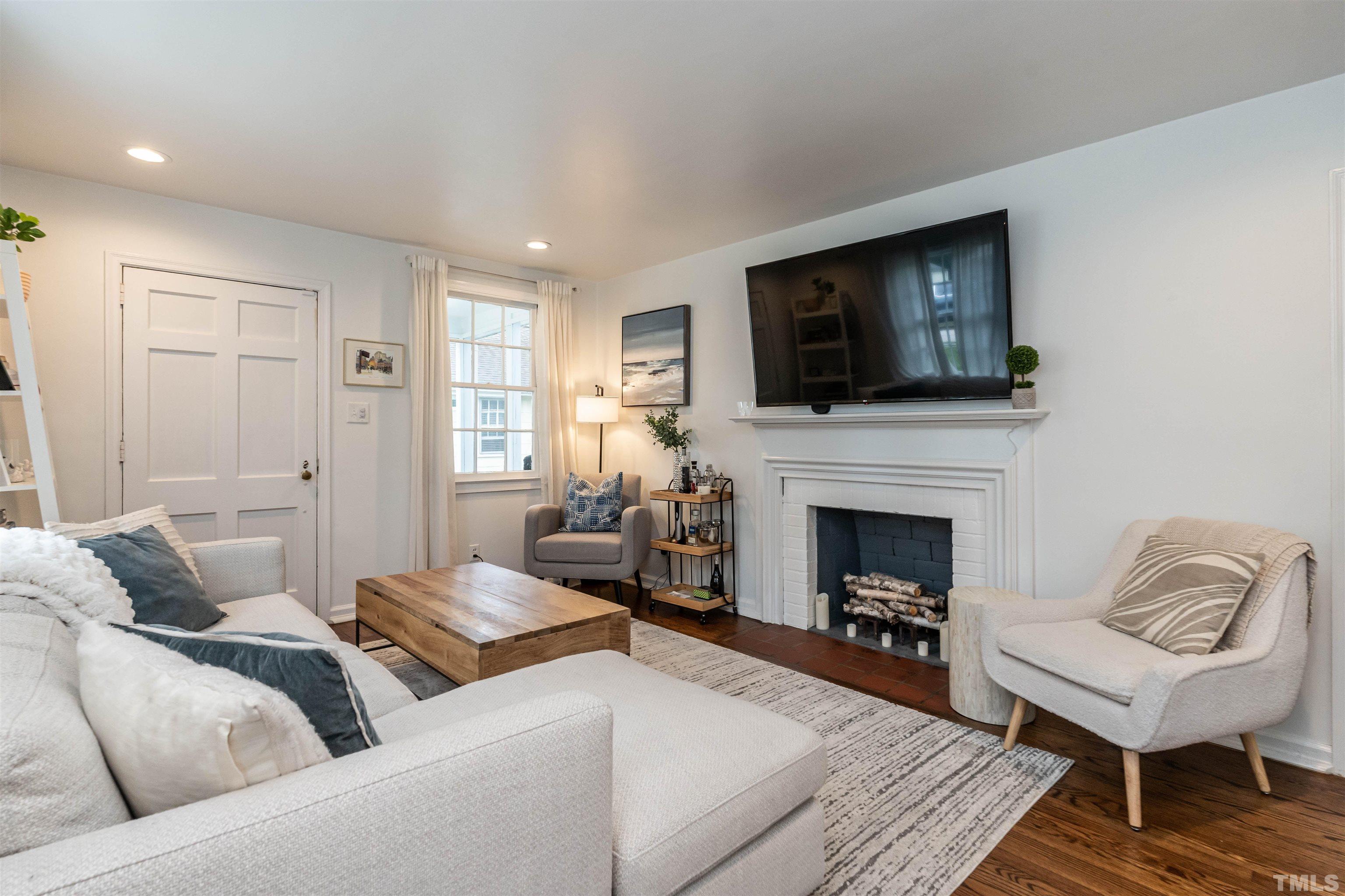 1204 Clifton Street Raleigh, NC 27604 - Photo 5 of 26 a living room with furniture a flat screen tv and a fireplace