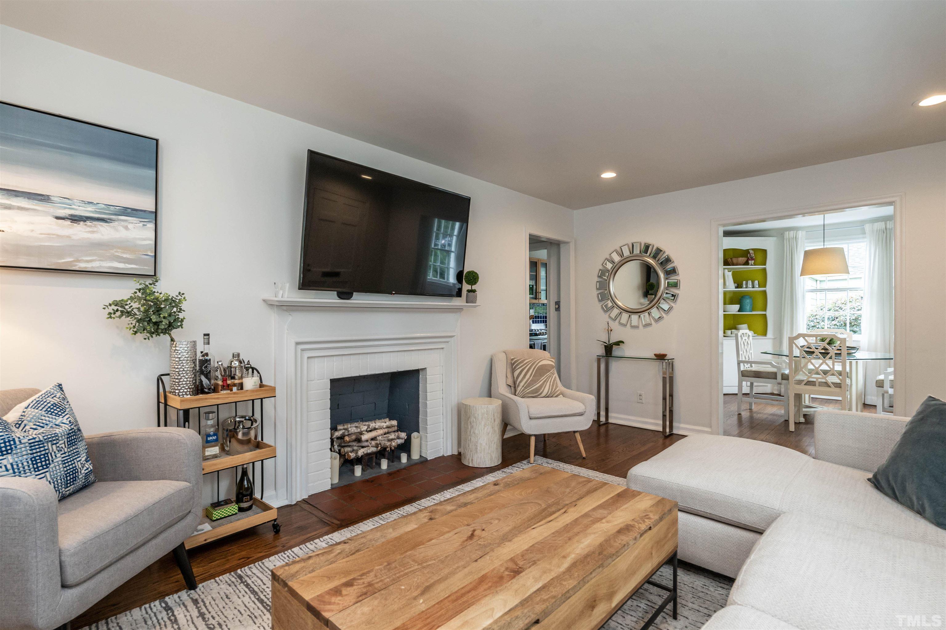 1204 Clifton Street Raleigh, NC 27604 - Photo 6 of 26 a living room with furniture a fireplace and a flat screen tv