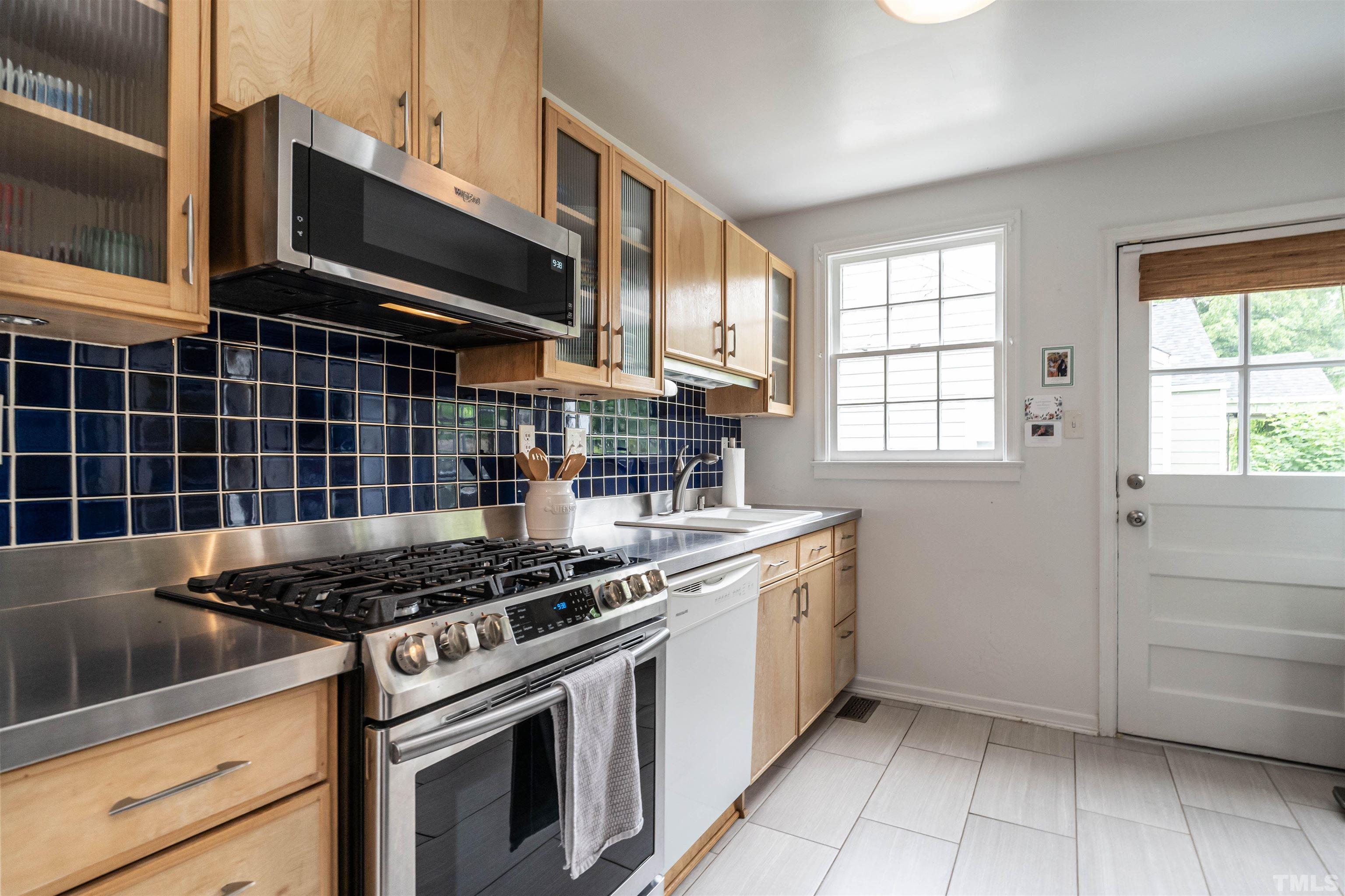 1204 Clifton Street Raleigh, NC 27604 - Photo 10 of 26 a kitchen with stainless steel appliances granite countertop a stove and a microwave