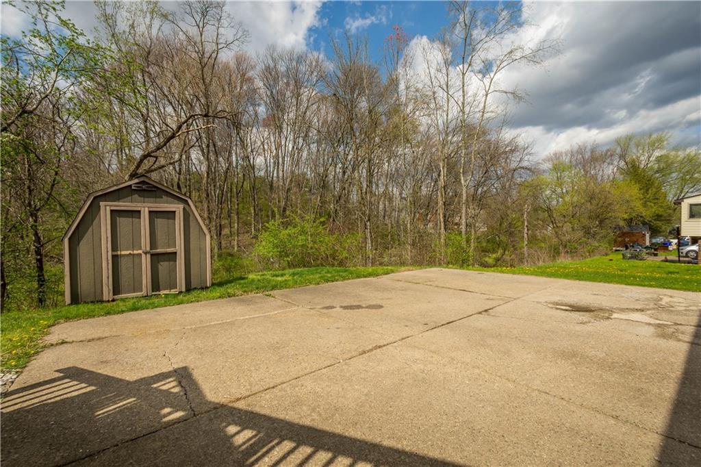 137 Walnut Strand Imperial, PA 15126 - Photo 28 of 37 a backyard of a house with large trees and cars parked