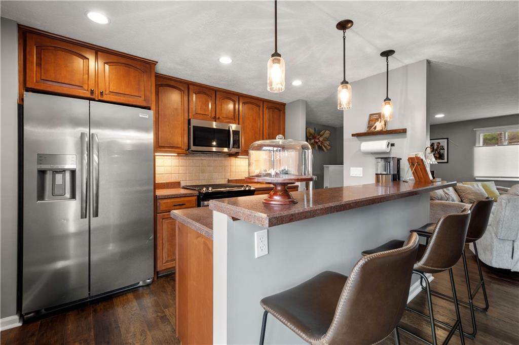 137 Walnut Strand Imperial, PA 15126 - Photo 8 of 37 a kitchen with stainless steel appliances granite countertop a refrigerator a stove a sink a dining table and chairs with wooden floor