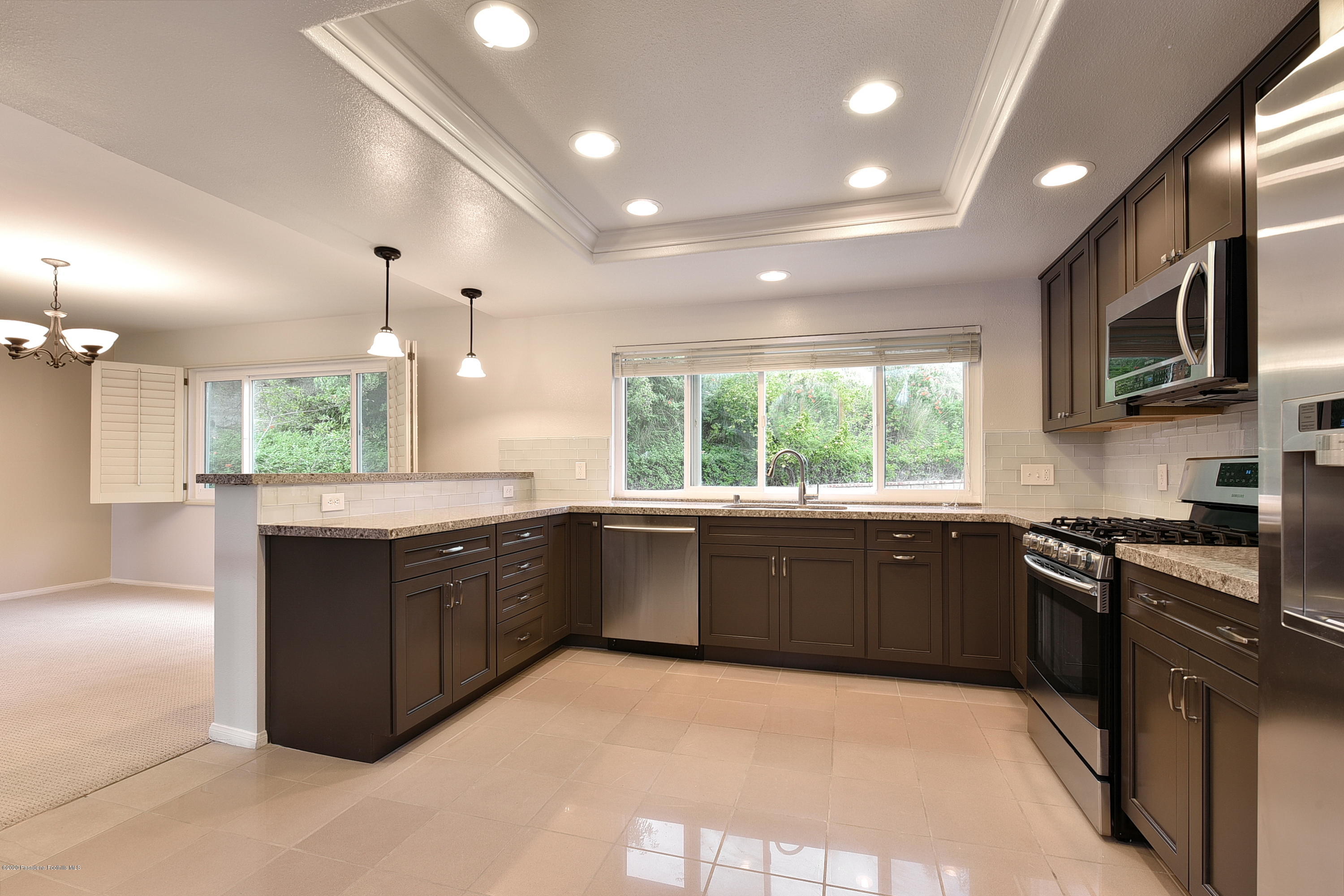 3107 Chadney Drive Glendale, CA 91206 - Photo 7 of 26 a large kitchen with granite countertop a stove top oven a sink dishwasher a dining table and chairs with wooden floor