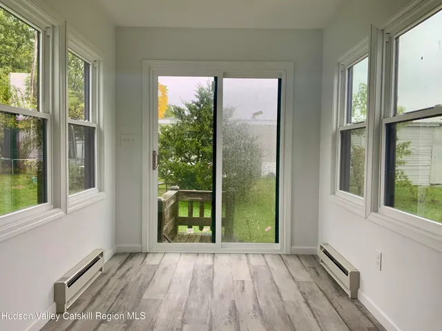 an empty room with wooden floor and a window