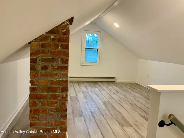 a view of a hallway with wooden floor and windows