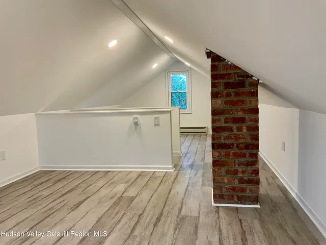 a view of an empty room with wooden floor and entryway