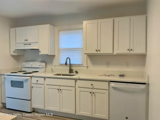 a kitchen with white cabinets and white appliances