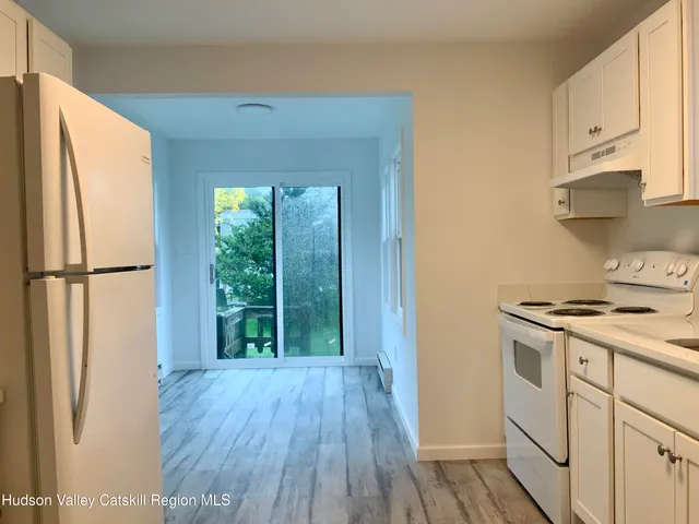 a kitchen with a white cabinets and wooden floor