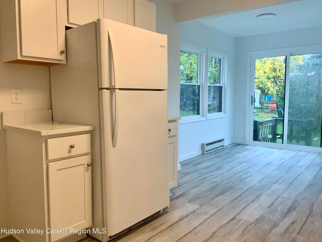 a white refrigerator freezer and a wooden floor
