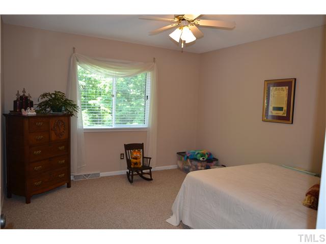1701 Baker Road Raleigh, NC 27607 - Photo 11 of 25 a bedroom with a bed and a chandelier