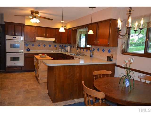 1701 Baker Road Raleigh, NC 27607 - Photo 3 of 25 a kitchen with stainless steel appliances granite countertop a sink a stove microwave and cabinets