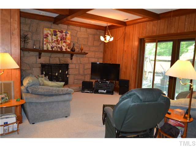 1701 Baker Road Raleigh, NC 27607 - Photo 6 of 25 a living room with furniture a flat screen tv and a fireplace