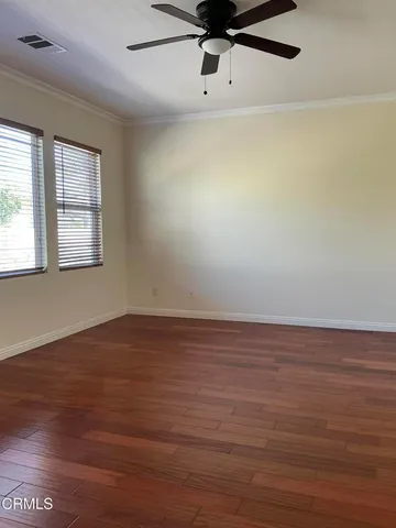a view of an empty room with wooden floor