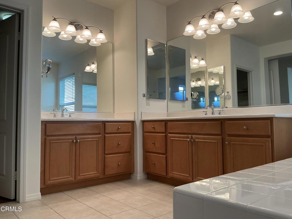 13687 Blue Ridge Way Moorpark, CA 93021 - Photo 32 of 46 a spacious bathroom with a granite countertop sink a large mirror and cabinets