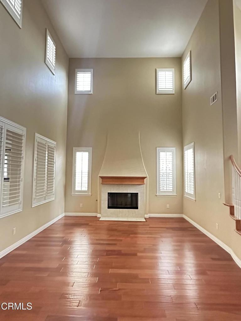 13687 Blue Ridge Way Moorpark, CA 93021 - Photo 4 of 46 an empty room with wooden floor fireplace and windows