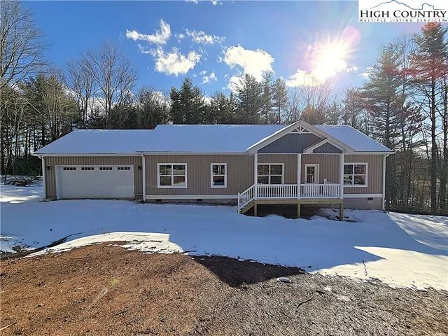 a front view of a house with a yard covered in snow