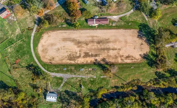 an aerial view of a house with a yard and large trees