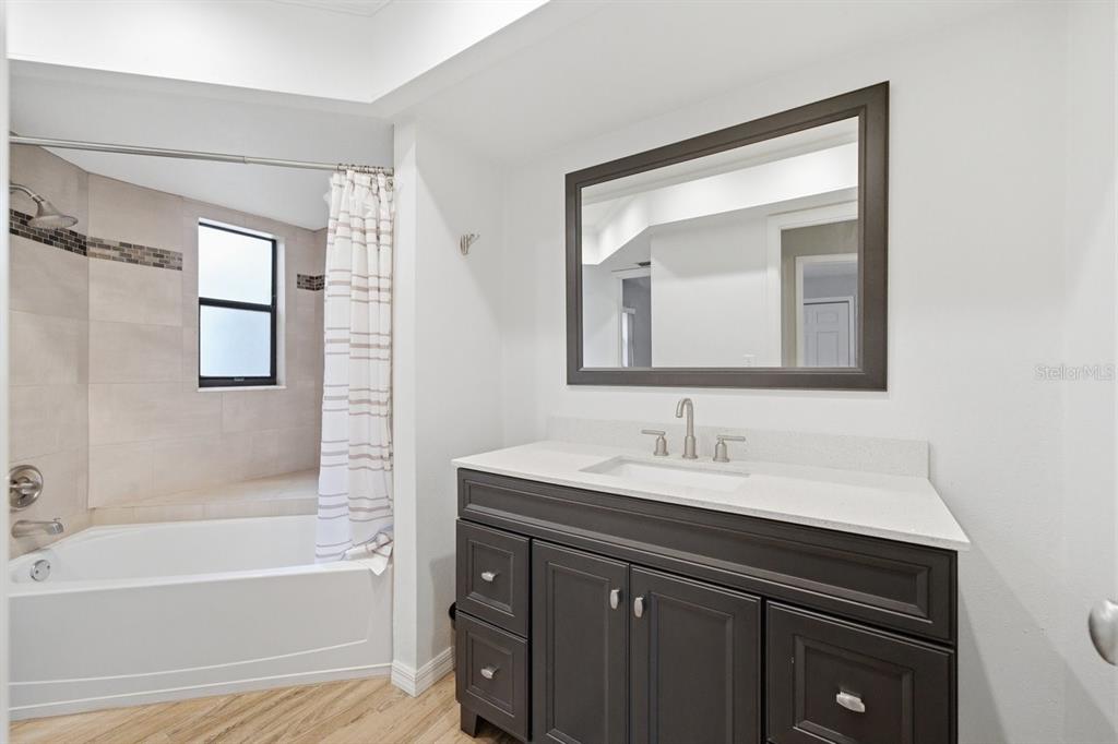 8316 Kingsdale Street Spring Hill, FL 34608 - Photo 19 of 30 a bathroom with a sink vanity tub and a mirror