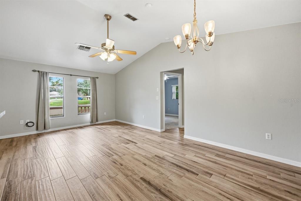 8316 Kingsdale Street Spring Hill, FL 34608 - Photo 7 of 30 a view of an empty room with wooden floor and a window