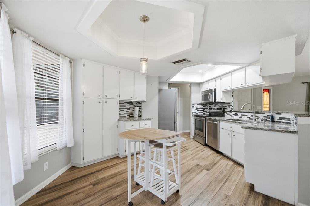 8316 Kingsdale Street Spring Hill, FL 34608 - Photo 8 of 30 a kitchen with stainless steel appliances kitchen island granite countertop a stove refrigerator and cabinets