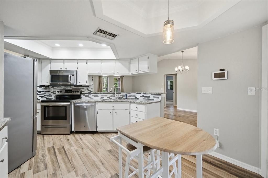 8316 Kingsdale Street Spring Hill, FL 34608 - Photo 9 of 30 a kitchen with granite countertop a sink appliances cabinets and counter space