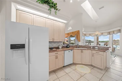a large white kitchen with granite countertop a sink