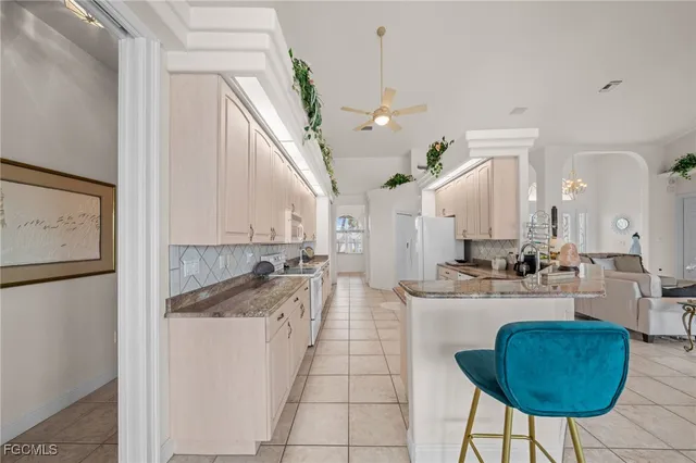 a kitchen with stainless steel appliances granite countertop a sink a stove and a refrigerator