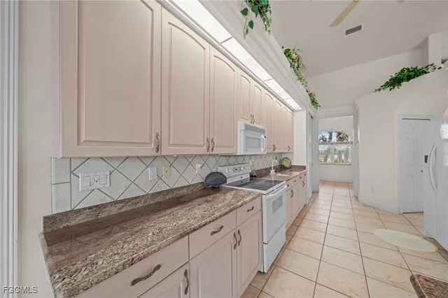 a large white kitchen with granite countertop a sink
