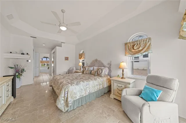 a spacious bedroom with a bed and a chandelier