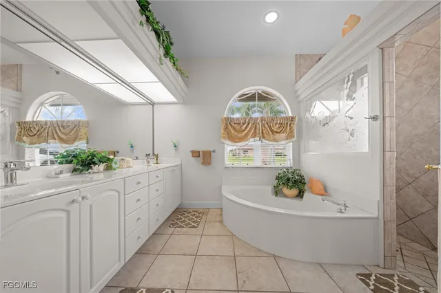a bathroom with a tub a sink and a large mirror