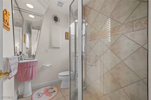 a bathroom with a granite countertop shower a sink and a toilet