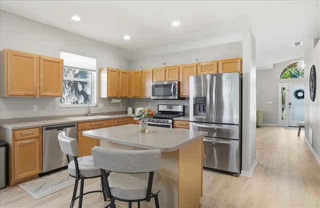 a living room with furniture kitchen view and a potted plant