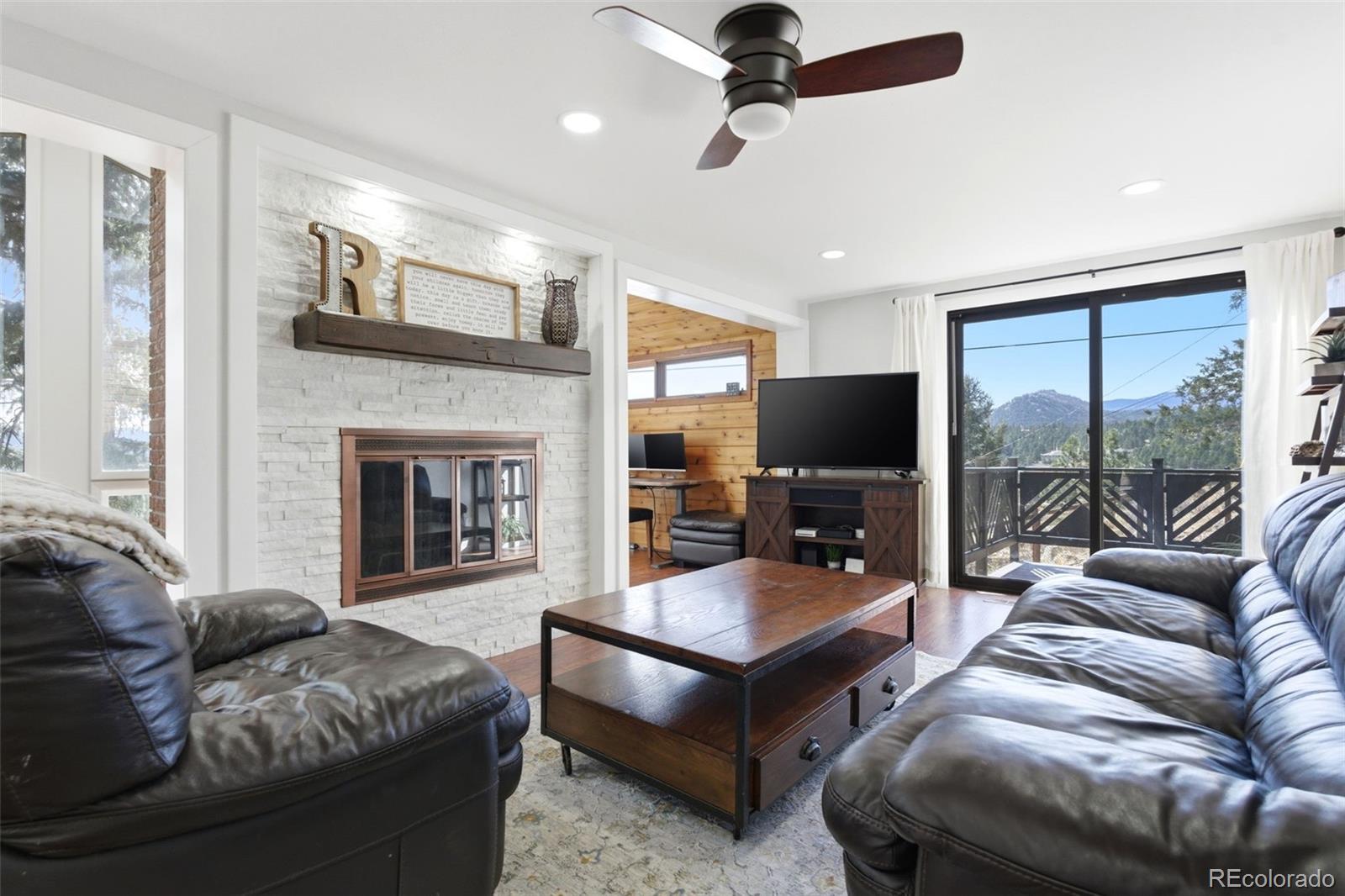 3155 Chestnut Circle Evergreen, CO 80439 - Photo 19 of 50 a living room with furniture a flat screen tv and a fireplace