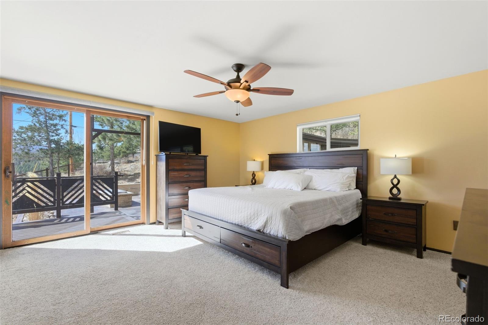 3155 Chestnut Circle Evergreen, CO 80439 - Photo 22 of 50 a spacious bedroom with a bed and glass door