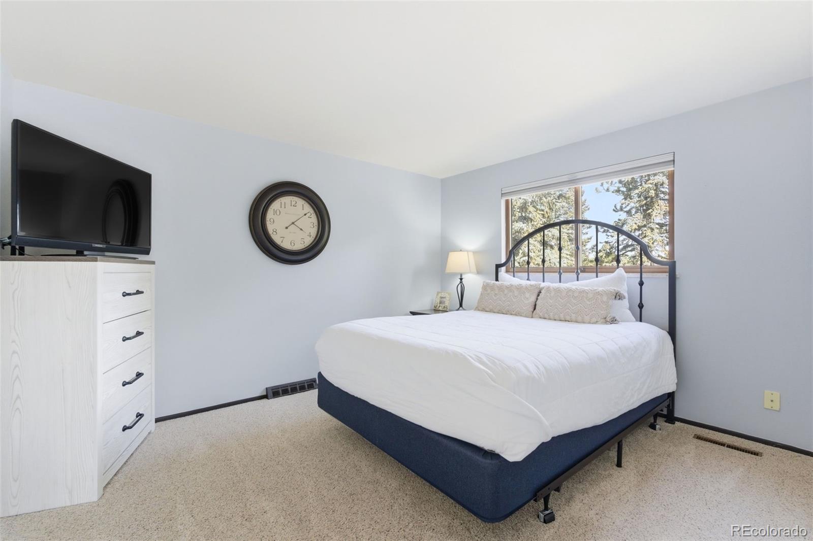 3155 Chestnut Circle Evergreen, CO 80439 - Photo 28 of 50 a bedroom with a bed and a flat screen tv