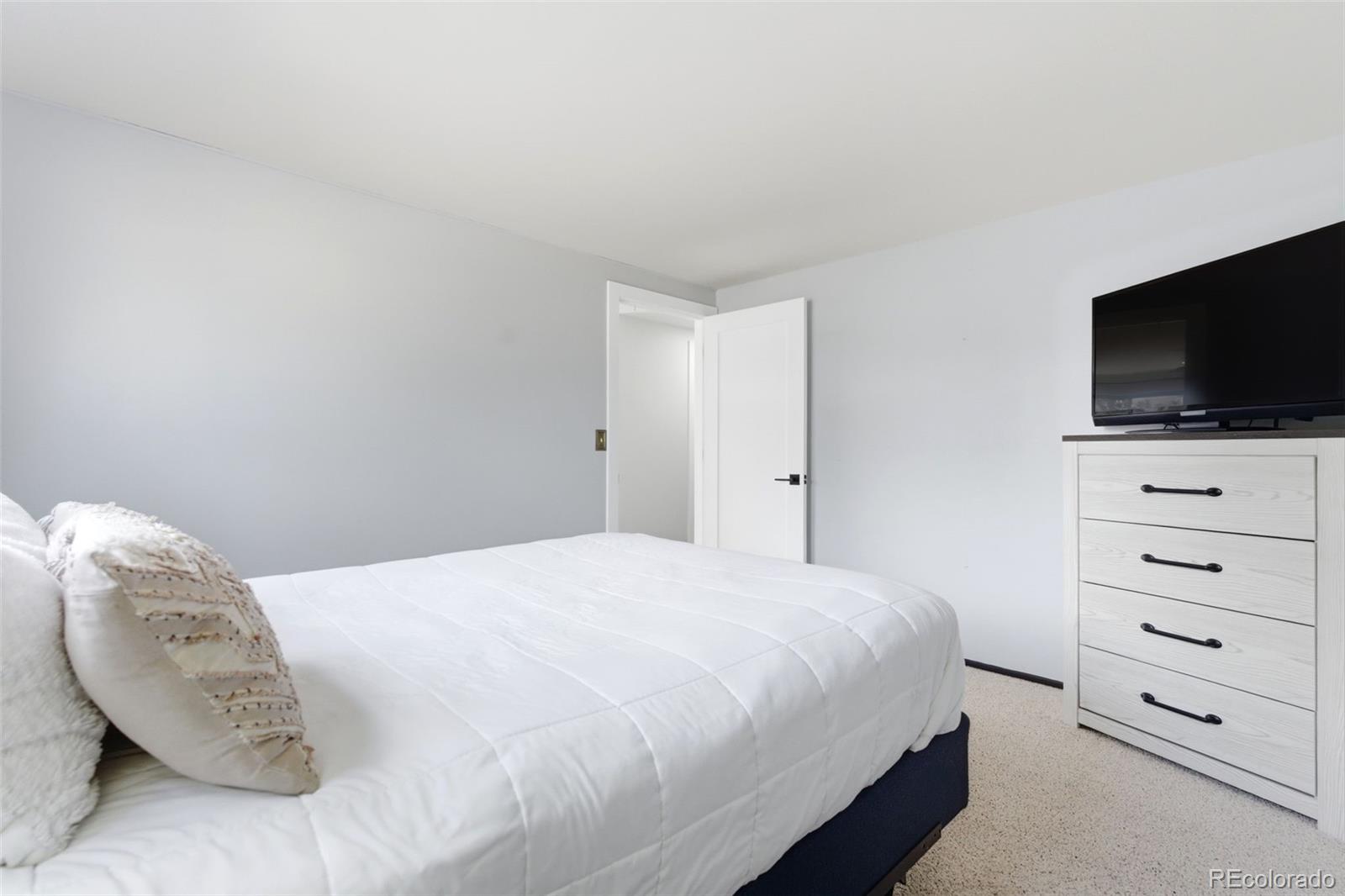 3155 Chestnut Circle Evergreen, CO 80439 - Photo 29 of 50 a bedroom with a bed and a flat screen tv