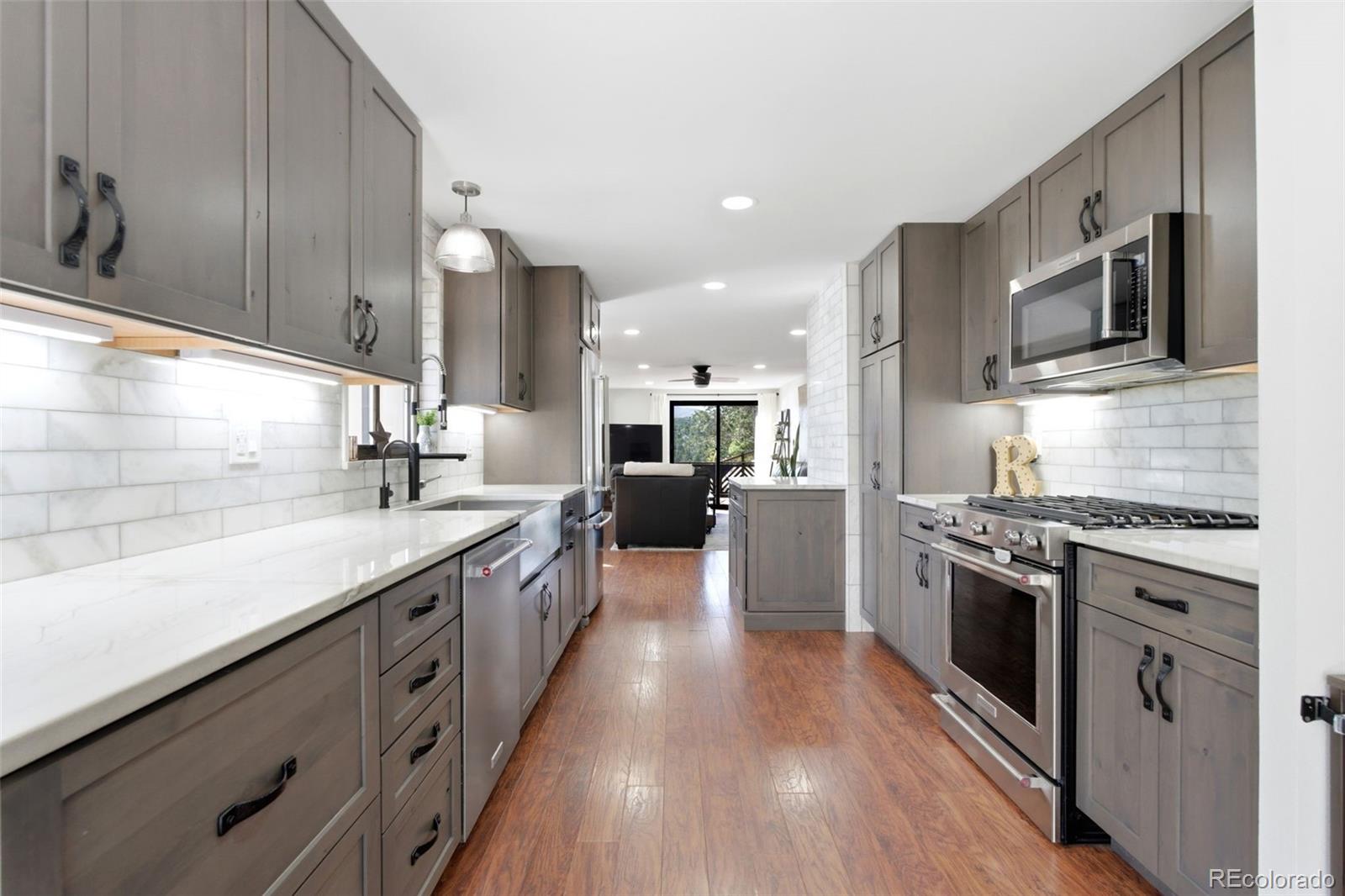 3155 Chestnut Circle Evergreen, CO 80439 - Photo 8 of 50 a large kitchen with stainless steel appliances granite countertop a lot of counter space and wooden floor