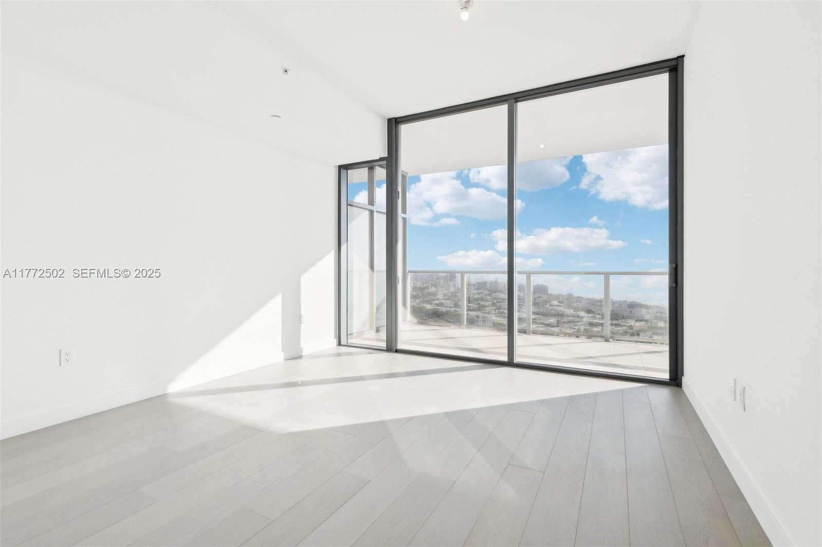 500 Alton Road, Unit 4201 05 Miami Beach, FL 33139 - Photo 23 of 61 an empty room with wooden floor and windows