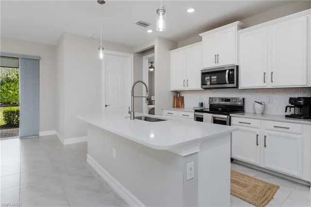 a kitchen with kitchen island a sink stainless steel appliances and cabinets