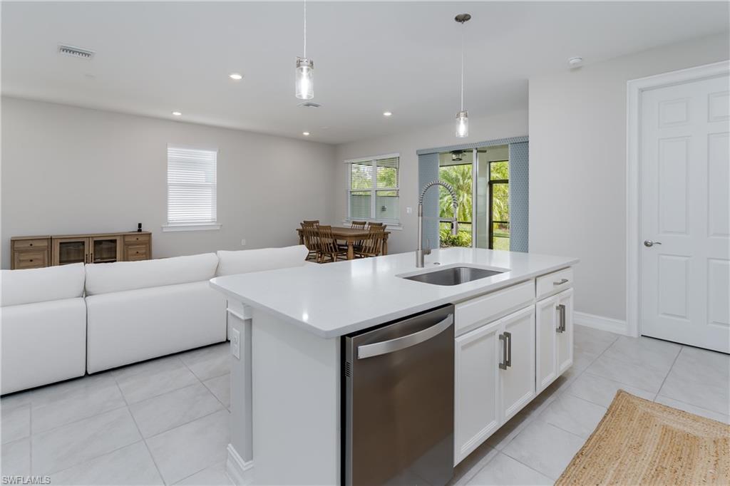 14643 Stillwater Way Naples, FL 34114 - Photo 12 of 50 a kitchen with counter top space and living room