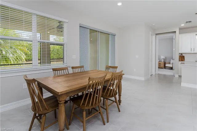 a view of a dining room and livingroom with furniture wooden floor and a large window