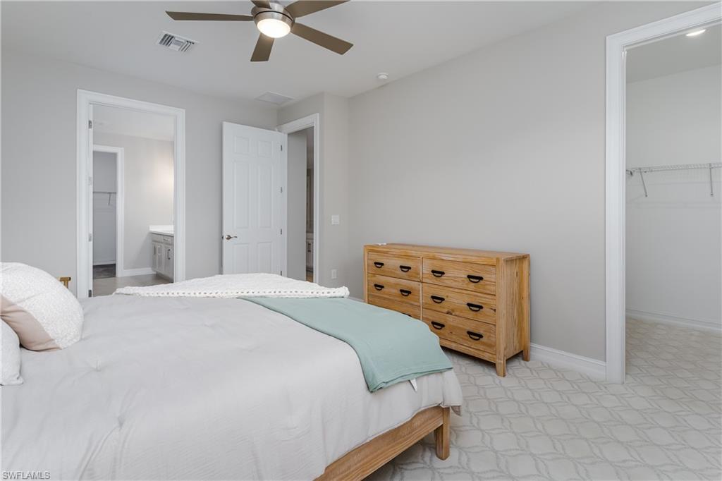 14643 Stillwater Way Naples, FL 34114 - Photo 18 of 50 a bedroom with a bed and a chandelier