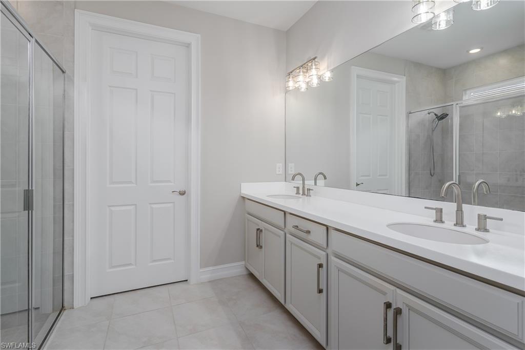 14643 Stillwater Way Naples, FL 34114 - Photo 21 of 50 a bathroom with a double vanity sink and a mirror