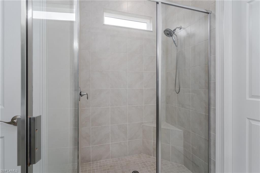 14643 Stillwater Way Naples, FL 34114 - Photo 22 of 50 a bathroom with a glass shower door