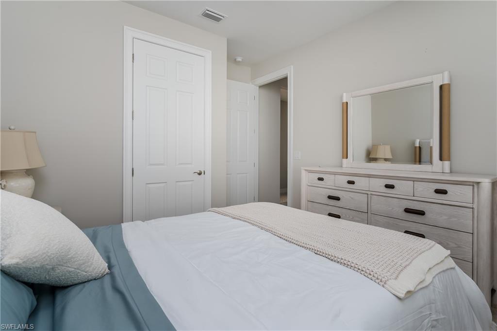 14643 Stillwater Way Naples, FL 34114 - Photo 24 of 50 a bedroom with a bed and a mirror on dresser