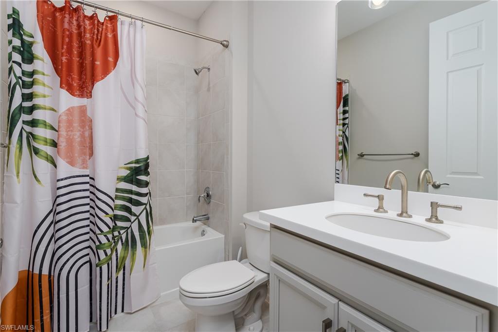 14643 Stillwater Way Naples, FL 34114 - Photo 25 of 50 a bathroom with a sink a toilet and a mirror