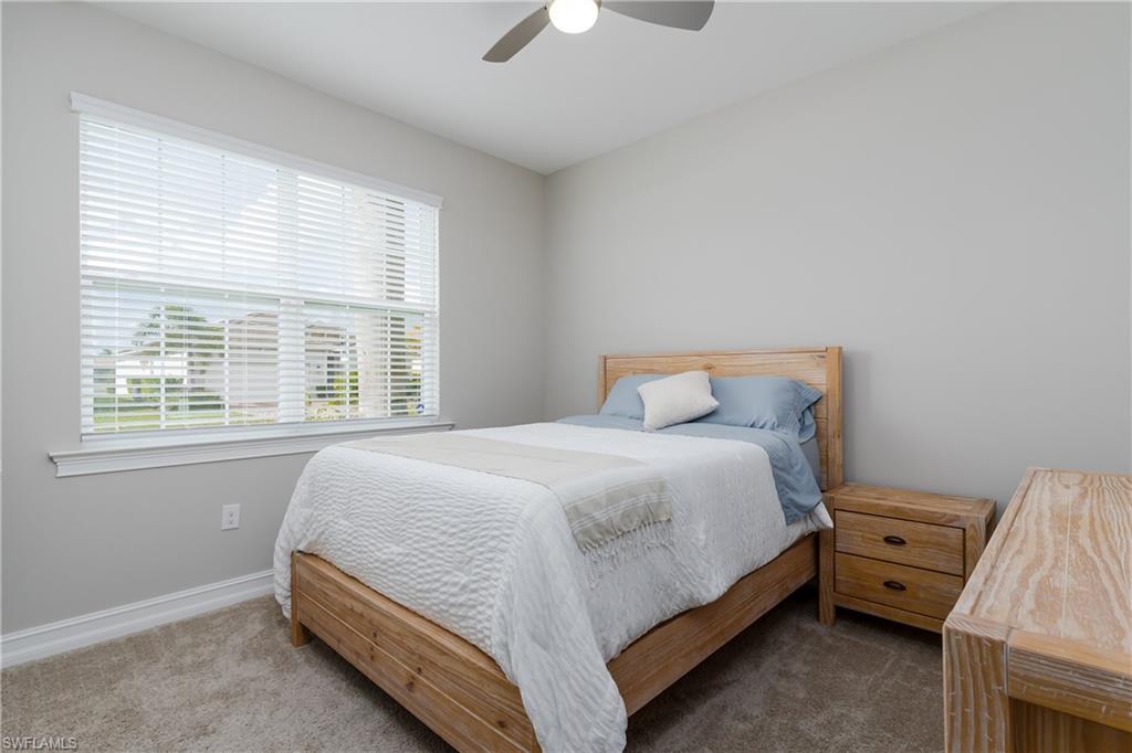 14643 Stillwater Way Naples, FL 34114 - Photo 26 of 50 a bedroom with a bed and a chandelier