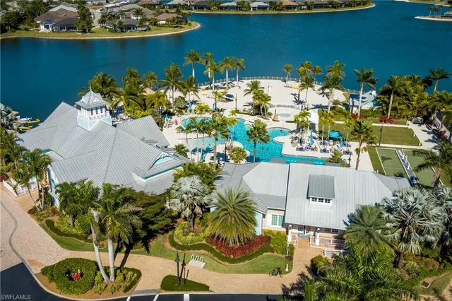 a picture of a white house with a lot of flower plants