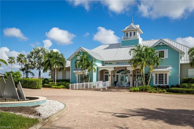 a front view of a house with garden and trees